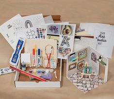 an assortment of arts and crafts items are displayed on a brown surface with other art supplies