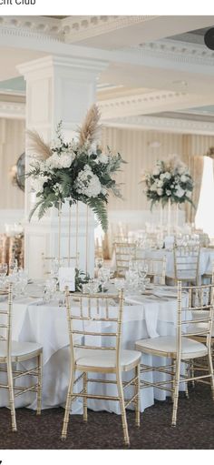 the tables are set with white linens and tall centerpieces