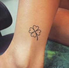 a woman's foot with a four leaf clover tattoo on her left side ankle