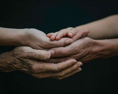 two adults and one child holding their hands together with the other hand on top of them