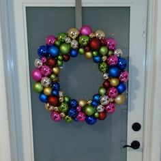 a door with a wreath made out of christmas ornaments on the front and side doors