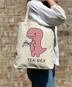 Funny Tea-Rex Tote Bag, Funny Dinosaur Tote Bag, Casual Tote Bag, Cute Tote, Nature Lover, Women Shoulder Shirt, Gift For Women, Tote Bag Aesthetic 🎉 Welcome to Our Eco-Chic Boutique! 🎉 💐 We're Absolutely Delighted to Have You! 💐 Diving into our boutique feels like uncovering a secret garden of treasures, all thoughtfully selected with you in mind. Our mission is to fill your world with joy and satisfaction, handpicking each piece to ensure your shopping journey with us is nothing short of wonderful. 🌿 A Personalized Shopping Experience Awaits: 🌿 Discover Your Unique Style: Wander through our bespoke collection and find the tote bag that feels like a piece of your soul. Each one tells its own story--are you ready to tell yours? Find Your Perfect Match: Our premium linen tote bags com Eco Bag Aesthetic, Tote Aesthetic, Tote Bag Men, Tea Rex, Aesthetic Bag, Funny Dinosaur, Funny Tote Bags, Special Text, Tote Bag Aesthetic