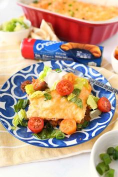 a blue and white plate topped with lasagna casserole