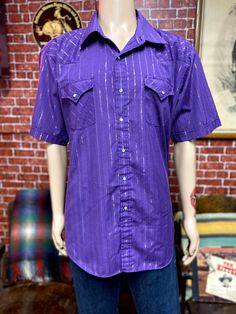 "Vintage men's western cowboy rodeo ranch purple shirt short sleeve size 2xl. Two chest pockets, pearl snap on buttons. Good used condition, tag label Ely Cattleman. Please, check carefully the measurements, photos and description of the article before buying it, we do not accept changes or returns. Measuraments lying face down from outside: 28\" Across chest underarm to underarm. 21 1/2\" Shoulder seam to seam. 11 Sleeve length from shoulder seam to hem. 32\" Long, collar to hem down. Let me kn Western Style Short Sleeve Shirt For Rodeo, Summer Rodeo Shirt With Pockets, Fitted Short Sleeve Shirt For Rodeo, Western Short Sleeve Tops With Button Closure, Vintage Short Sleeve Shirt For Rodeo, Purple Short Sleeve Tops With Pockets, Summer Vintage Purple Shirt, Western Short Sleeve Shirt With Button Closure, Vintage Short Sleeve Purple Shirt