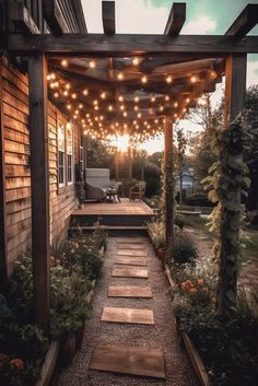 an outdoor patio with lights strung over it and steps leading up to the front door