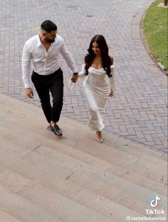 a man and woman are walking down the stairs