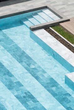 an empty swimming pool with steps leading up to the edge and grass in the middle