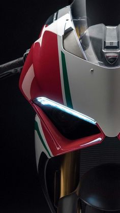 the front end of a red and white motorcycle