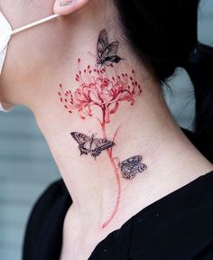 a woman with a tattoo on her neck has a flower and butterflies on the back of her neck