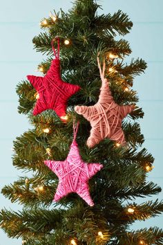 three star ornaments hanging from a christmas tree