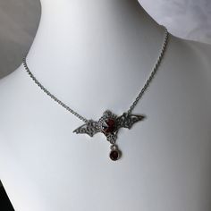 "This gothic vampire inspired necklace is made with an antiqued silver plated filigree bat and findings, accented with sparkling glass crystals in DARK RUBY RED. Wingspan is 2 1/4\" wide and centerpiece is 1 1/2\" tall in the center. necklace isadjustable 15-18\" with a lobster clasp and chain extender in the back. If you would like a different length or stone color, please send us a message. Matching headpiece is available in our store." Silver Vampire Style Necklace, Gothic Nickel-free Necklace For Halloween, Gothic Nickel-free Necklaces For Halloween, Gothic Red Jewelry For Halloween, Red Gothic Jewelry For Halloween, Silver Vampire Style Metal Jewelry, Silver Vampire Costume Jewelry, Silver Vampire Style Costume Jewelry, Victorian Silver Costume Jewelry