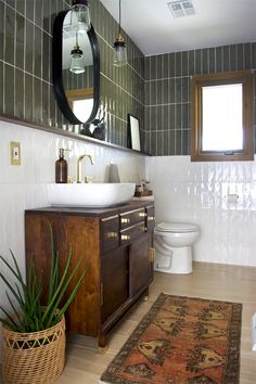 a bathroom with a sink, mirror and rug on the floor in front of it