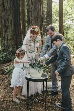 a couple of people that are standing in the dirt near a table with flowers on it