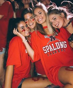 three girls in red shirts posing for the camera