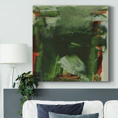 an abstract painting hangs on the wall above a white couch with blue and green pillows