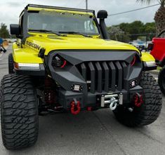 a yellow jeep is parked in a parking lot