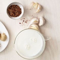 two white plates with food on them next to some garlic and other foodstuffs