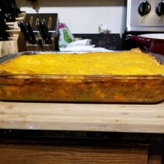 a large casserole dish sitting on top of a wooden counter in a kitchen