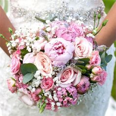 a bride holding a bouquet of pink flowers