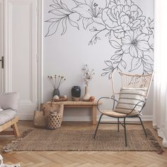 a living room with flowers painted on the wall and a chair in front of it