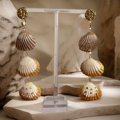 Make a bold statement with our Golden Shell Trio Statement Earrings.  These longline earrings feature three shells hand-painted in shimmering gold metallic hues, accented with delicate gold detailing for a truly unique style. Attached to gold-plated studs, these earrings exude elegance and sophistication. Elevate your look with these gorgeous statement earrings that are sure to turn heads wherever you go. uk postage. Royal Mail. 2-3 business days.  Thanks for being here,  Marie @MooiMuu XOXO Ocean-inspired Gold Jewelry For Party, Gold Shell With Matching Earrings, Handmade Ocean-inspired Gold Earrings, Luxury Gold Shell Earrings, Gold Ocean-inspired Earrings, Gold Shell Dangle Earrings, Gold Shell-shaped Earrings For Party, Gold Dangle Shell Earrings, Gold Brass Shell Earrings