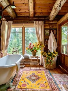 a bath tub sitting next to a window in a room filled with furniture and flowers