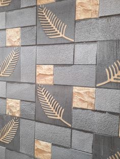 a close up of a wall made out of bricks with a fern leaf on it