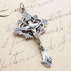 Size: 1 5/8 x 7/8 inch Material: Sterling silver This beautiful crucifix is decorated in the art nouveau style. The ends are budded and scrolled with an open-work trefoil framing the center. It's a very nice size to wear on a chain and not too heavy. The medal was cast in sterling silver from an antique medal in the Rosa Mystica Collection so it shows all the beauty and history of the original piece. It comes with a matching holy card in an organza gift bag, ready for gift-giving, and was made i Silver Crucifix For Wedding, Rosa Mystica, Crucifix Art, Valentine Gift For Wife, Art Nouveau Silver, Confirmation Gifts, Art Nouveau Style, Cross Jewelry, Organza Gift Bags