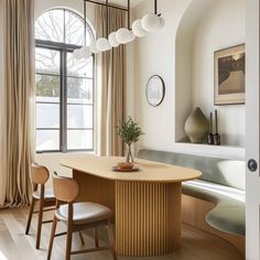 a dining room table and chairs in front of a large window with arched glass doors