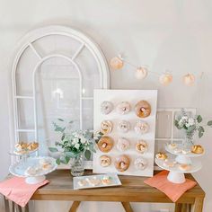 a table topped with donuts covered in frosting next to a vase filled with flowers