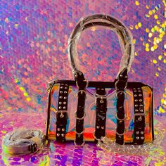 . This Mini Duffle Bag Has A Clear Holographic Vinyl Construction, Chain Detailing, Spiked And D-Ring Hardware, Top Handles, An Adjustable Shoulder Strap, And A Top Zipper Closure. Rainbow 100% Polyurethaneapprox. 10.5" W X 6.5" H X 4" D Mini Duffle Bag, Holographic Bag, Rainbow Holographic, Buckle Bag, Buckle Bags, Holographic Vinyl, Pink Faux Fur, New Dolls, Cute Bags