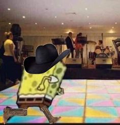 a man in a black hat is dancing on the dance floor with other people behind him