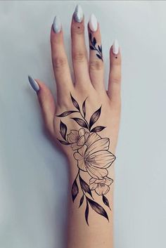 a woman's hand with a flower tattoo on it