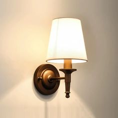 a wall light with a white shade on it