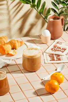 there are oranges and croissants on the table