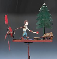 a sculpture of a man pulling a cart with a christmas tree on it