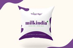 a pillow with the words milkindia on it in front of an abstract purple and white background