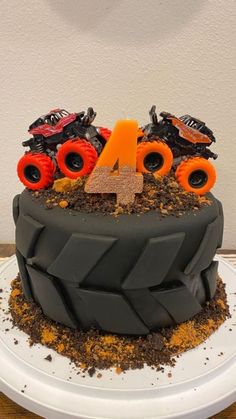 a birthday cake decorated with monster trucks and dirt