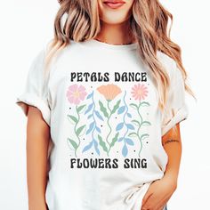 Create your own style with our floral boho chic shirt, where every petal sways and every blossom harmonizes with nature's chorus. This unique garden bloom t-shirt captures the essence of a nature lover's dream, featuring a whimsical "Petals Dance Flowers Sing" design that brings the bohemian botanical vibe to life. It's the perfect flowered shirt gift for mom or anyone who carries the spirit of the great outdoors in their heart. Our boho floral design comes in our popular Comfort Colors t-shirt White Hippie T-shirt For Spring, Bohemian Spring Shirt With Plants Print, Bohemian Shirt With Plants Print For Spring, White Floral Print Hippie Top, Bohemian Short Sleeve Shirt With Plant Print, Bohemian Floral Print Relaxed Fit Shirt, Bohemian Floral Print Shirt With Relaxed Fit, Bohemian Relaxed Fit Floral Print Shirt, Bohemian Relaxed Fit Floral Shirt