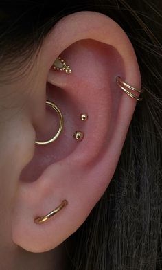 an ear with three different types of piercings on the top and bottom of it