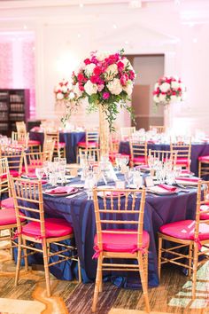 the tables are set up with pink and blue linens for an elegant wedding reception