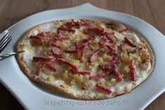 a small pizza on a white plate with a fork