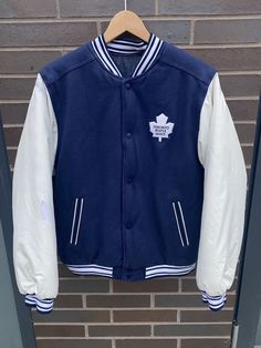 Vintage 1990s Toronto Maple Leafs Reversible Jacket - No Tag (Length 25" Chest 20") - Fits: Medium - Overall used vintage condition - Hole on left arm varsity side - Staining on collar/right shoulder (see pictures) - Message for more information Please take note of the measurements listed as these are vintage clothes and may fit different than the tag size. Follow our page for more vintage clothing drops! DISCLAIMER: All items are vintage so please be mindful that if by chance there is a flaw on Casual White Outerwear With Embroidered Patch, White Embroidered Patch Long Sleeve Outerwear, White Long Sleeve Outerwear With Embroidered Patch, White Embroidered Patch Outerwear For Streetwear, Winter White Outerwear With Embroidered Patch, White Embroidered Patch Outerwear For College, White Embroidered Outerwear For Streetwear, White Embroidered Winter Outerwear, Collegiate Long Sleeve Outerwear With Embroidered Patch