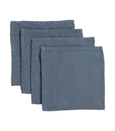 four blue linen napkins on a white background