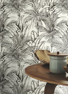 a table with a pot on top of it next to a wallpapered background