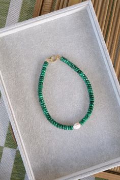 Brighten up your wardrobe with this standout piece! This necklace is made of vibrant green malachite with its unique, swirling patterns. Accented with a baroque pearl that adds a touch of glamour with its soft, iridescent glow and one-of-a-kind shape. 16" necklace. Malachite beads with large baroque pearl. Gold plated closure. Elegant Green Baroque Pearl Necklace, Green Baroque Pearl Jewelry For Gift, Green Handmade Pearl Necklace, Green Malachite Jewelry With Gemstone Beads, Green Malachite Gemstone Bead Jewelry, Malachite Necklace, Green Malachite, Swirl Pattern, Vibrant Green