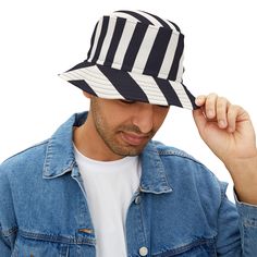 First, it protected fishermen from rain in the 1900s. Now, the black and white striped bucket hat is making its way to the very top of fashion picks for all ages. Choose the seam lines, add your zaniest designs and patterns on the bucket hat and make a modern wardrobe staple come to life.  .: Material: 100% polyester .: Available in 2 sizes .: Two stitching color options to pick from .: Sewn-in label .: Made in USA Navy Bucket Hat With Curved Brim For Summer, Black Retro Bucket Hat For Summer, Casual Striped Brimmed Bucket Hat, Summer Striped Cotton Hat, Spring Striped Adjustable Bucket Hat, Navy Bucket Hat For Summer, Casual Striped Short Brim Hat, Navy Summer Bucket Hat, Spring Striped Bucket Hat