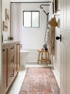 a bathroom with a rug, sink and toilet