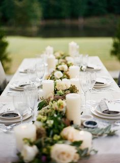 the table is set with candles and place settings for guests to sit down at it