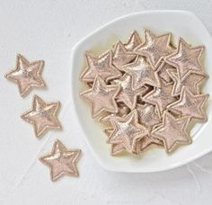 small gold stars on a white plate next to some smaller ones in the shape of stars